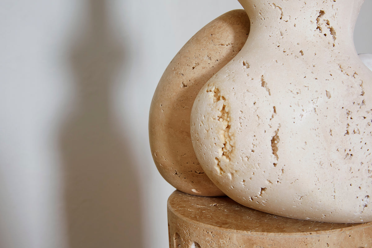 Closeup of carved travertine shapes sitting on a travertine base.