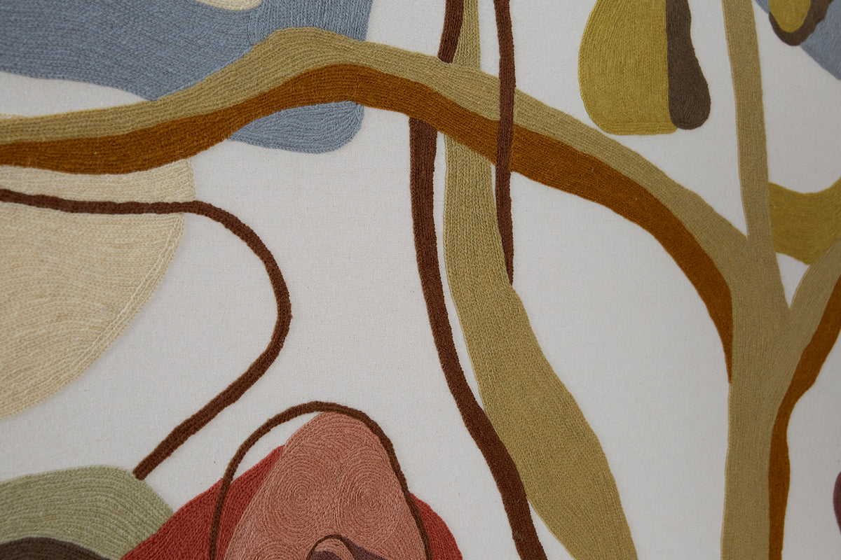Close-up of a textured fabric with abstract tree design in earthy tones.