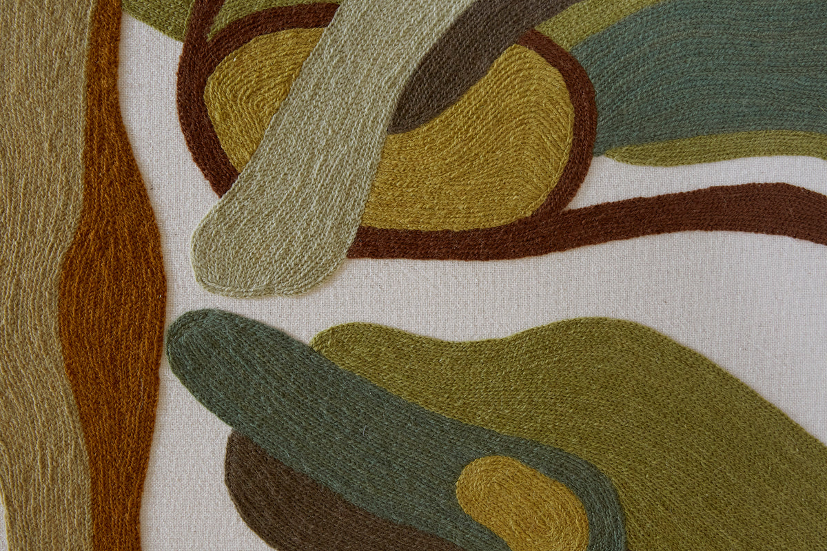 Close-up of a textured fabric with abstract patterns in brown, green, and beige.