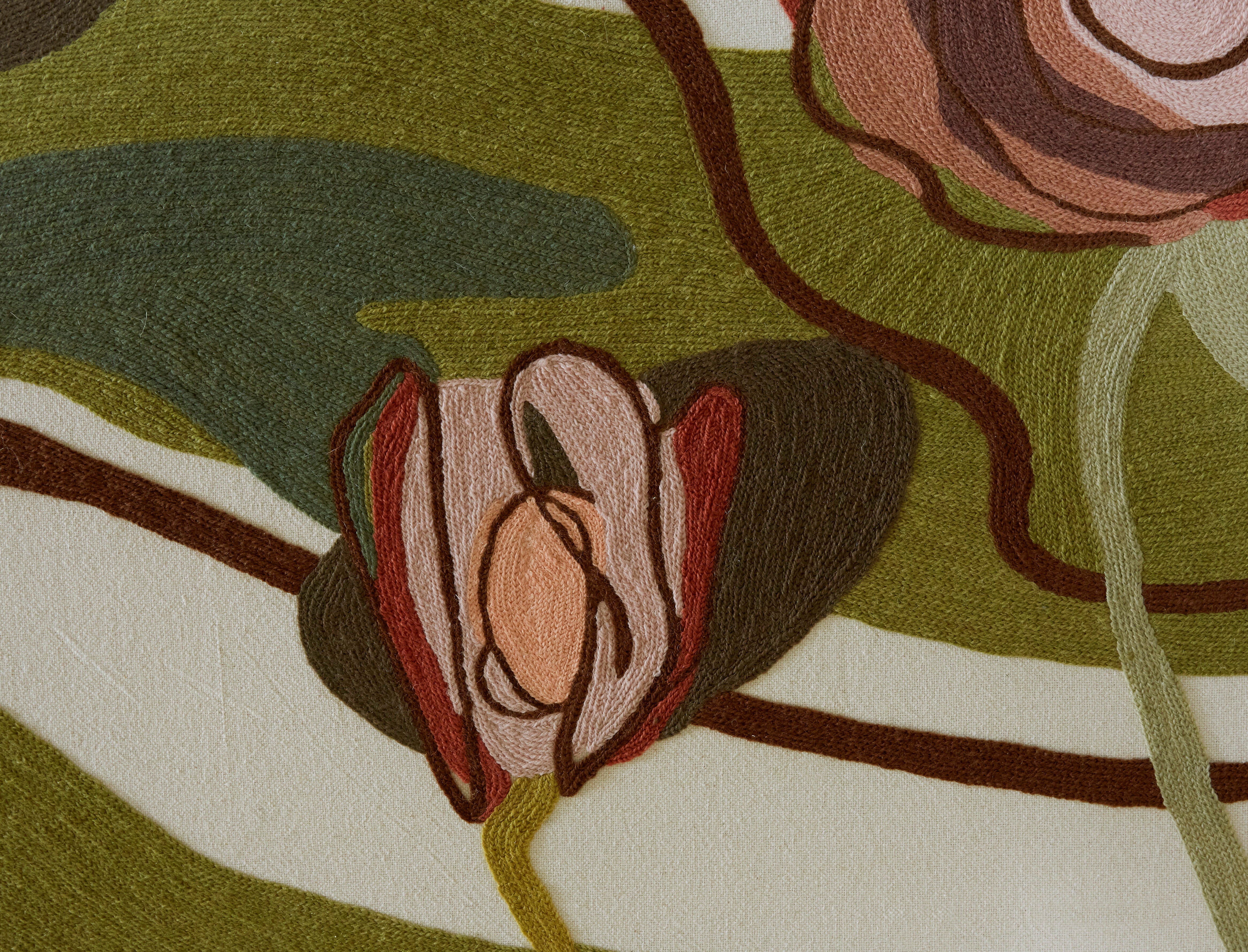 Close-up of a crewel fabric with earthy tones and abstract patterns.