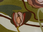 Close-up of a crewel fabric with earthy tones and abstract patterns.